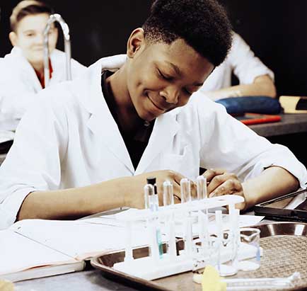Un garçon dans un laboratoire de sciences. 